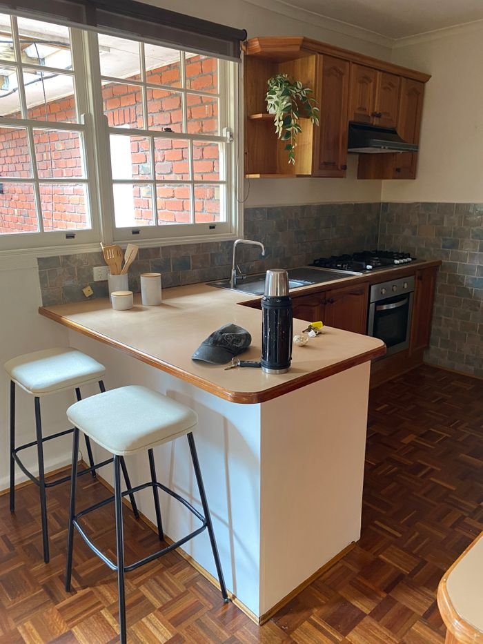 Inviting kitchen space with wooden cabinets and counter seating, perfect for home gatherings.