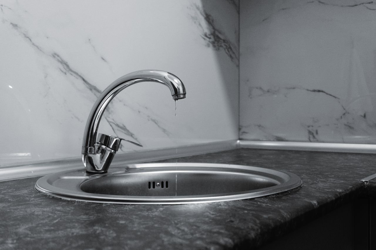 A clean and modern kitchen sink with a chrome faucet, highlighting minimalist design and water conservation.