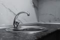 A clean and modern kitchen sink with a chrome faucet, highlighting minimalist design and water conservation.